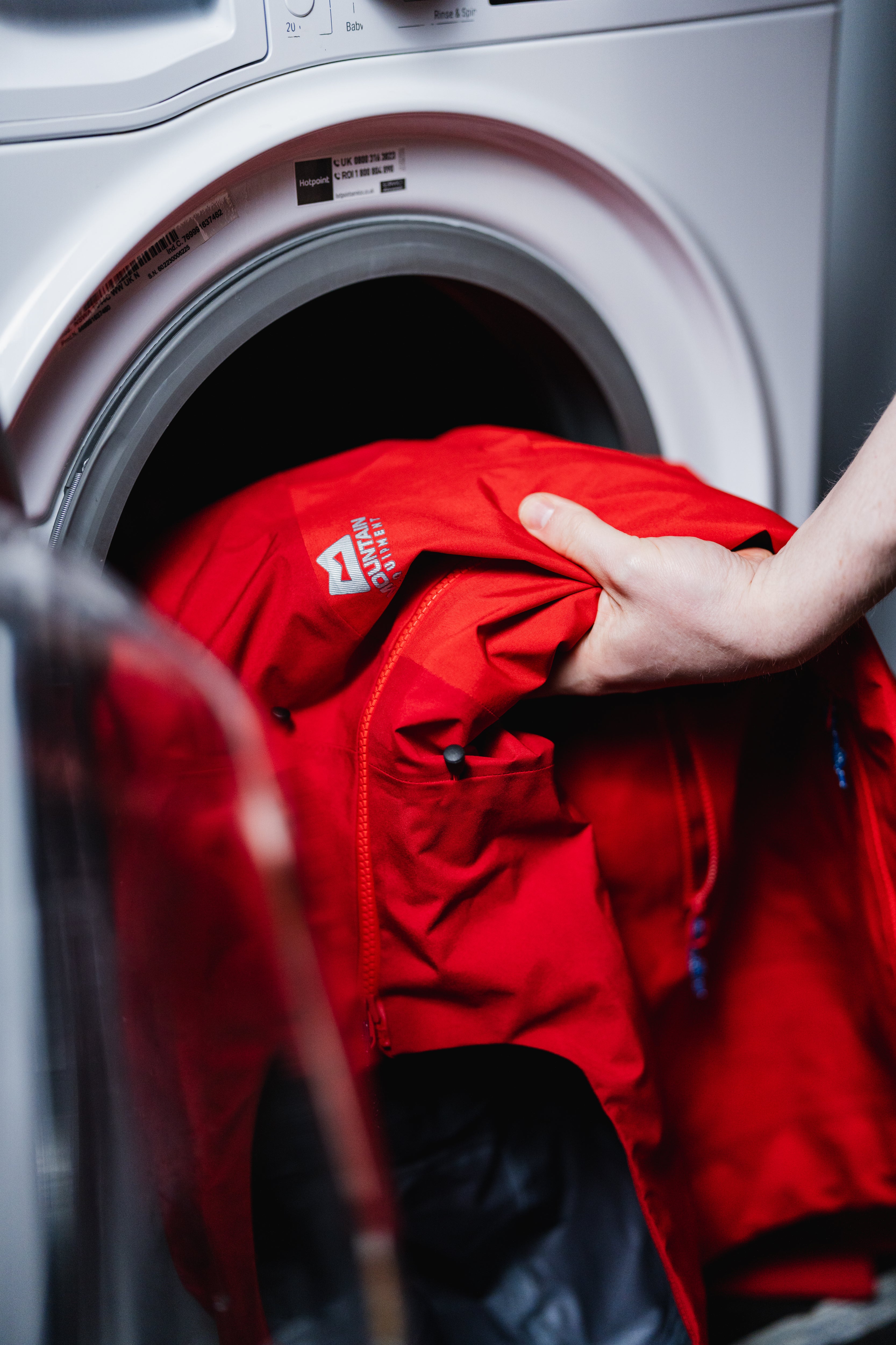 Eine wasserdichte Hardshelljacke von Mountain Equipment wird in einer Waschmaschine gewaschen.
