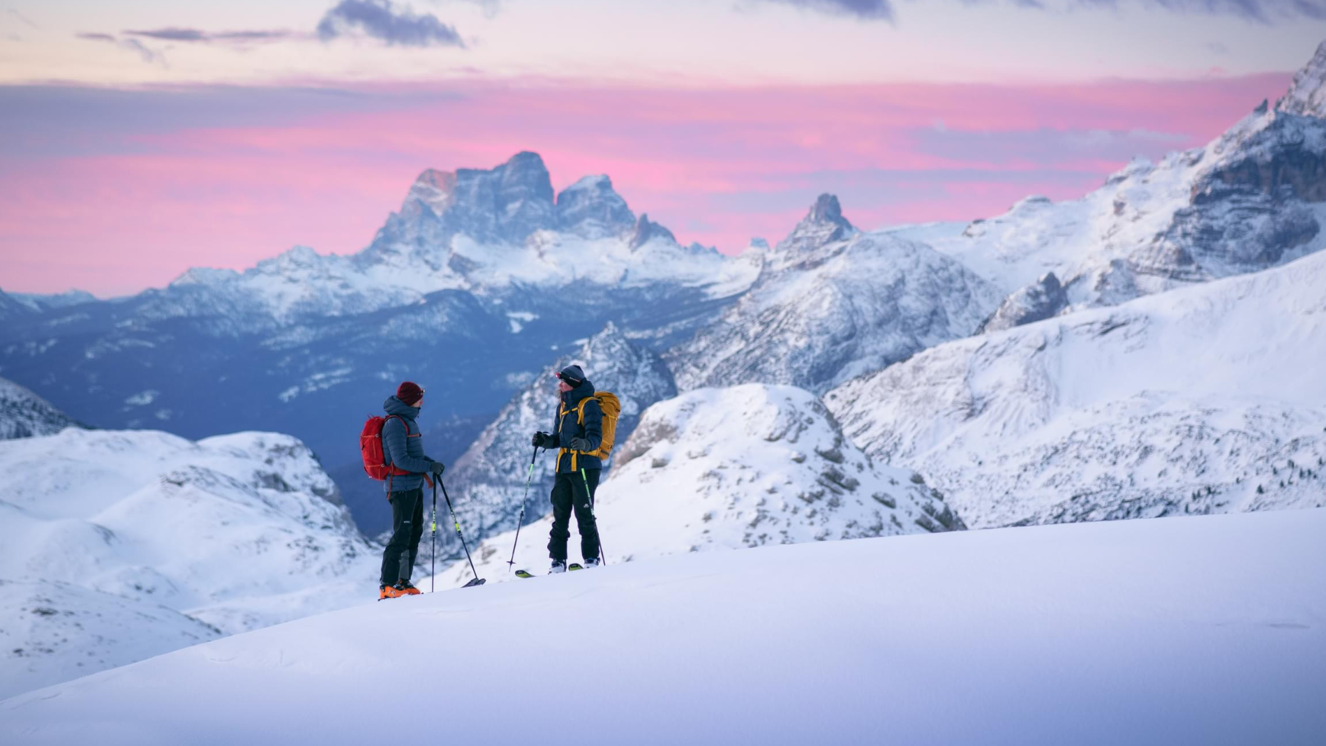 Zwei Menschen auf Skitour in Daunenjacken und Hardshelljacken von Mountain Equipment. 