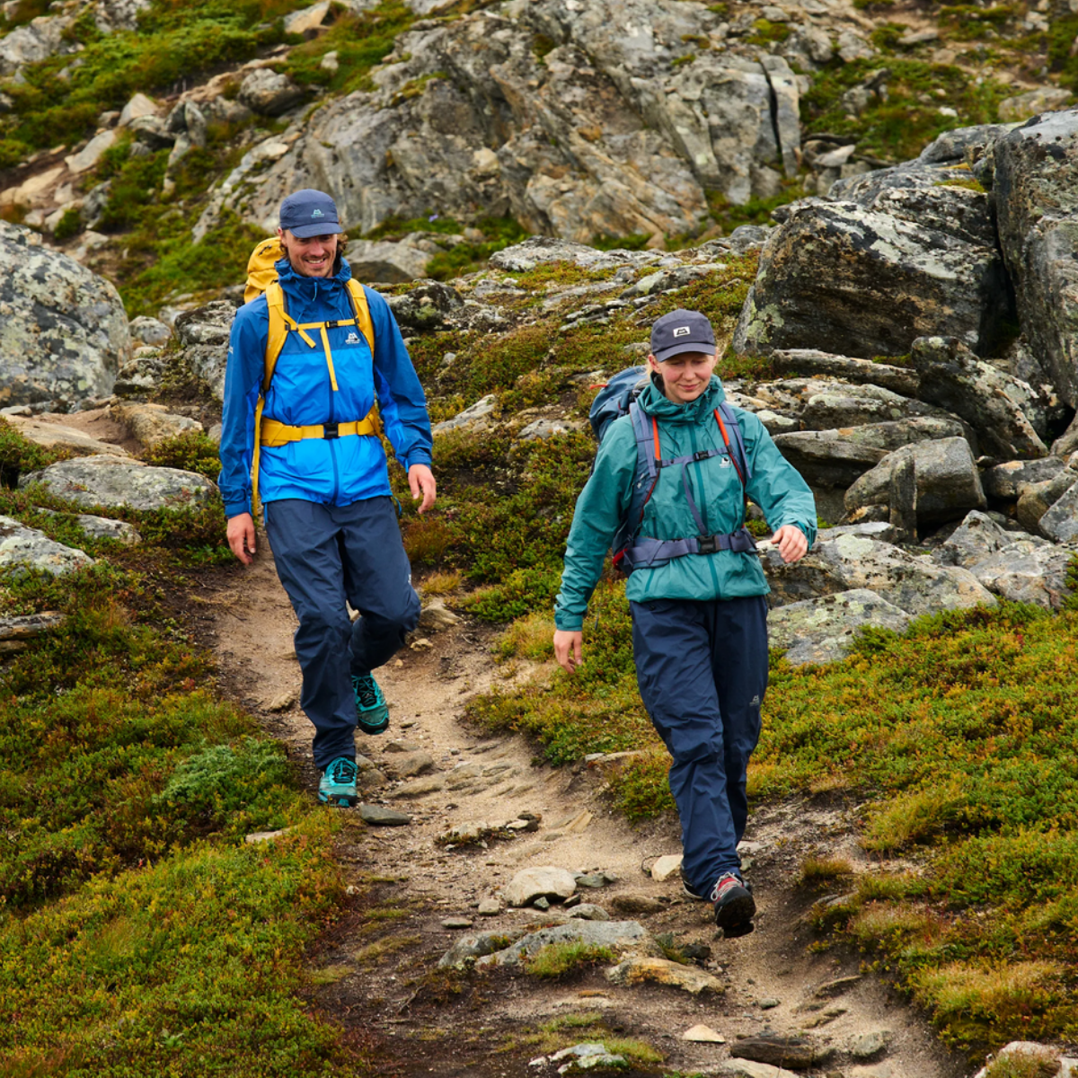 Zwei Wanderer in Norwegen, die mit Regenkleidung von Mountain Equipment einen Pfad in Norwegen entlang wandern.